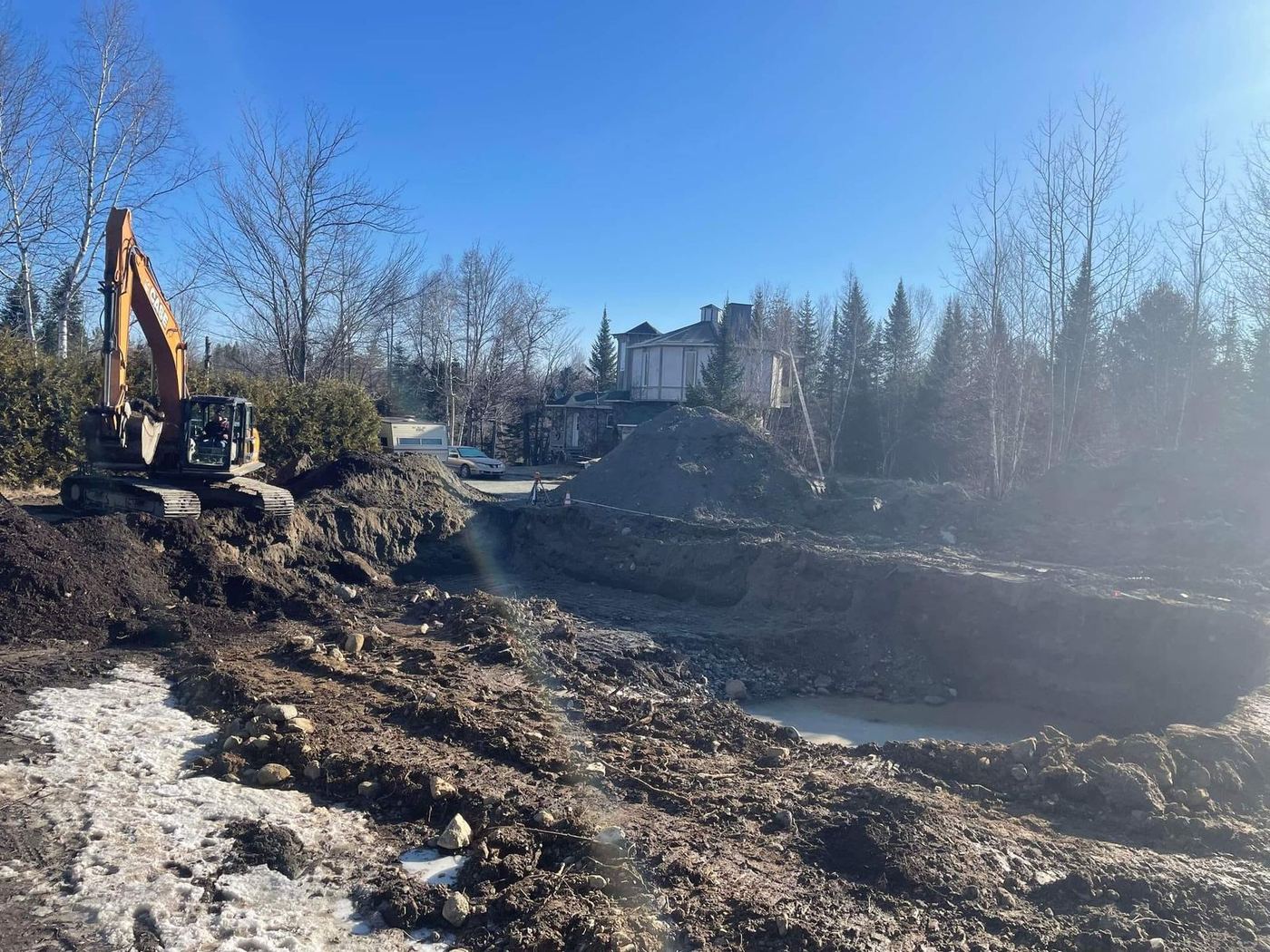 Chantier excavation profond deux excavatrice maison côte boisée