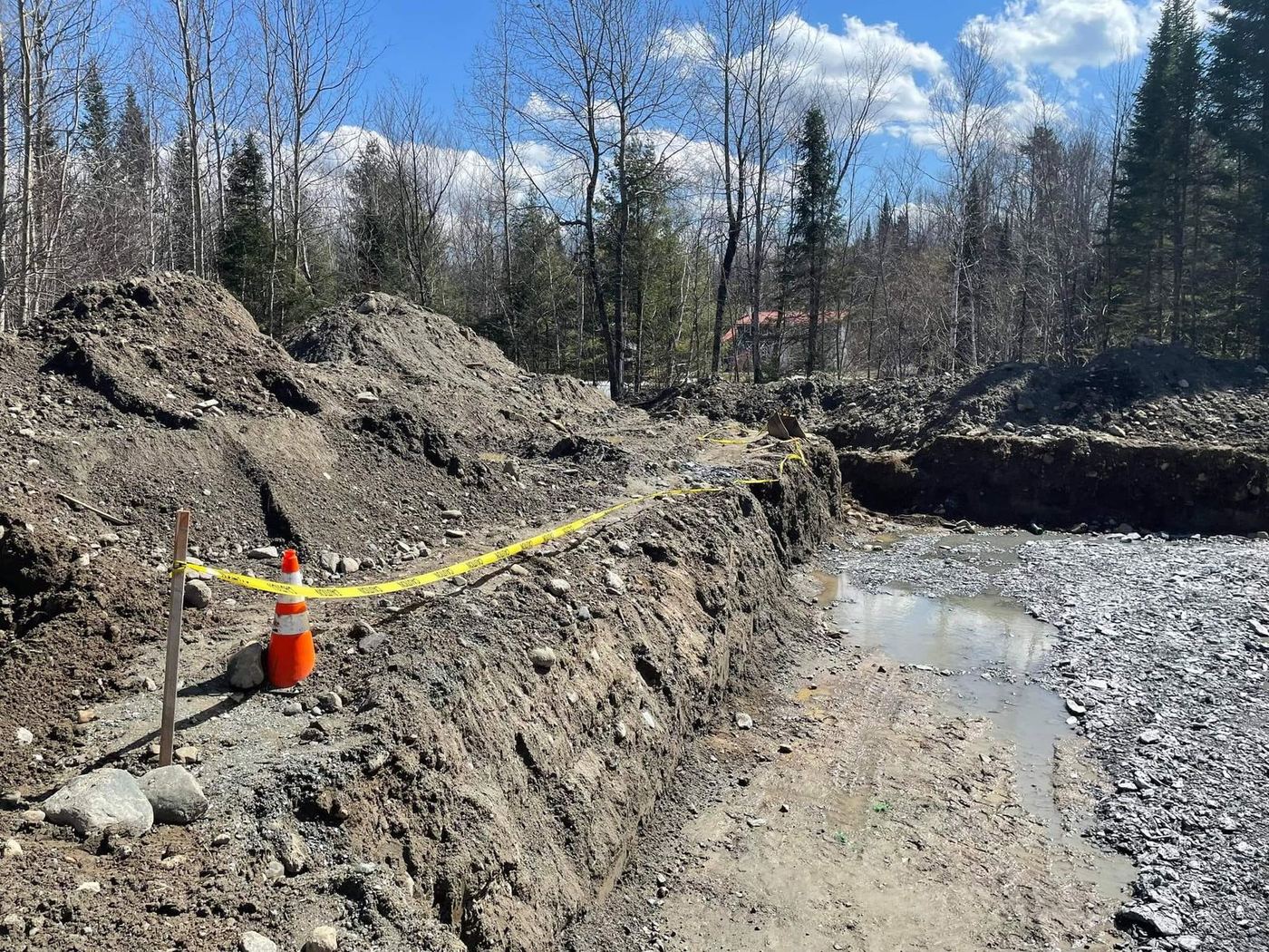 Grande tranchée avec eau, terrain boisé chantier important