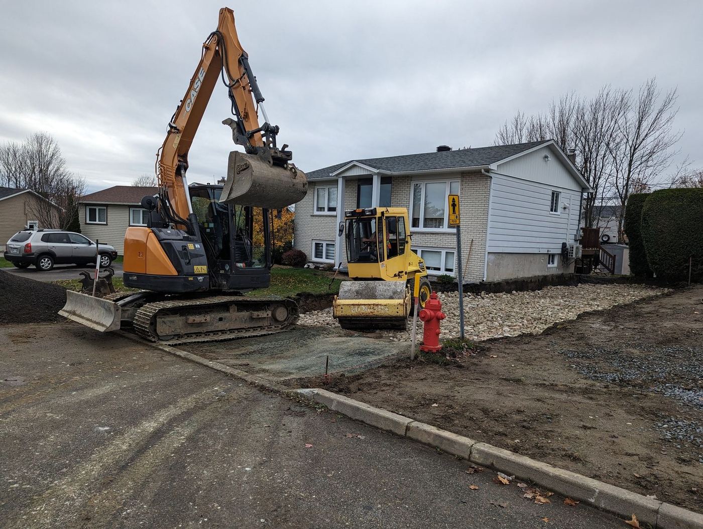 Grande excavatrice CASE et compacteur, préparation entrée résidentielle