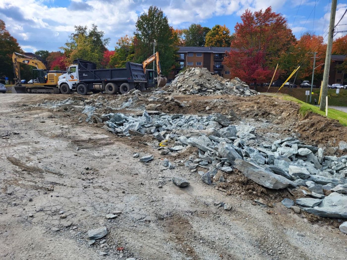 Grand chantier commercial avec camion-benne, roc concassé et excavatrice