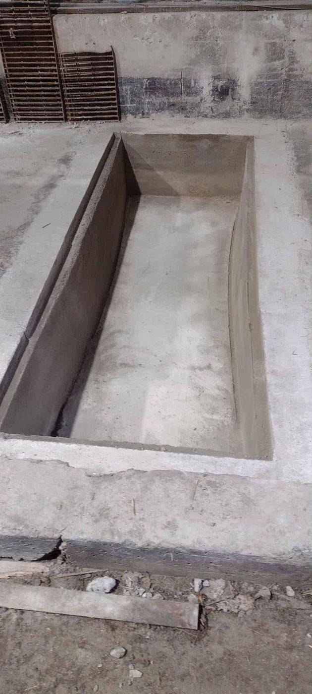Fosse en béton excavée et coffrée, intérieur bâtiment industriel