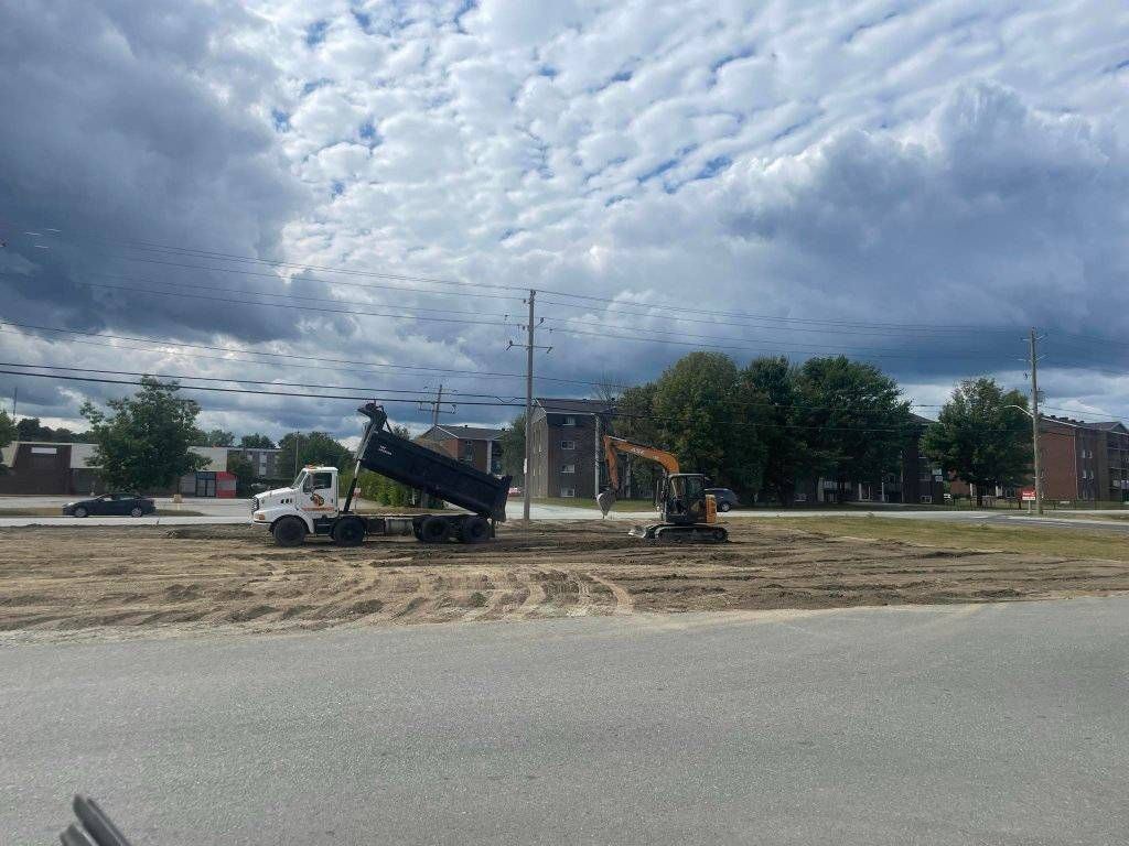 Camion-benne et excavatrice en opération, chantier commercial