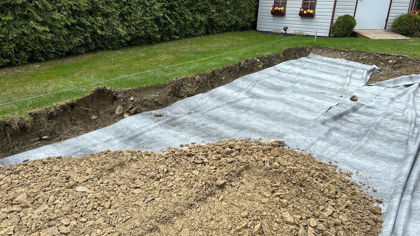 Tranchée drainage résidentielle géotextile et gravier installés