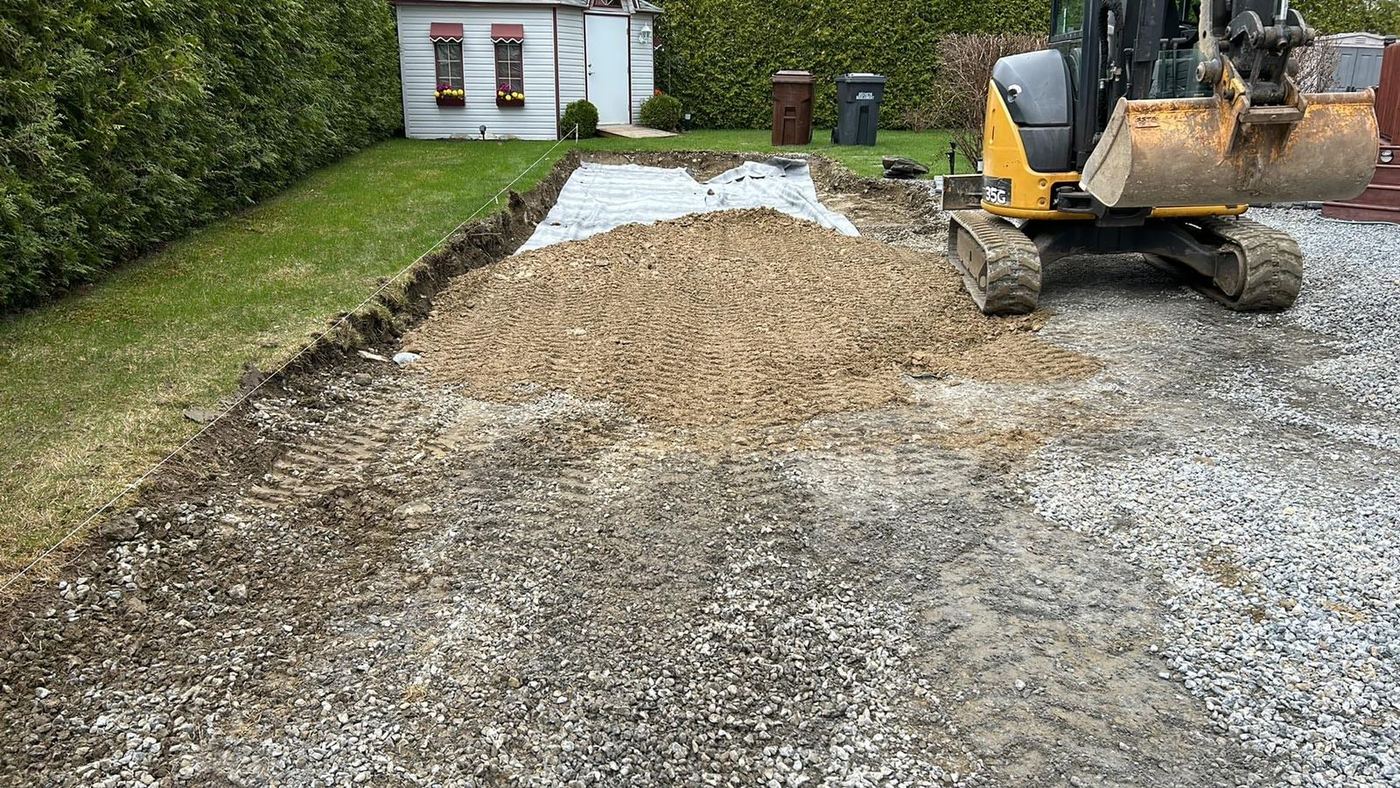 Mini-excavatrice étale gravier entrée résidentielle en cours