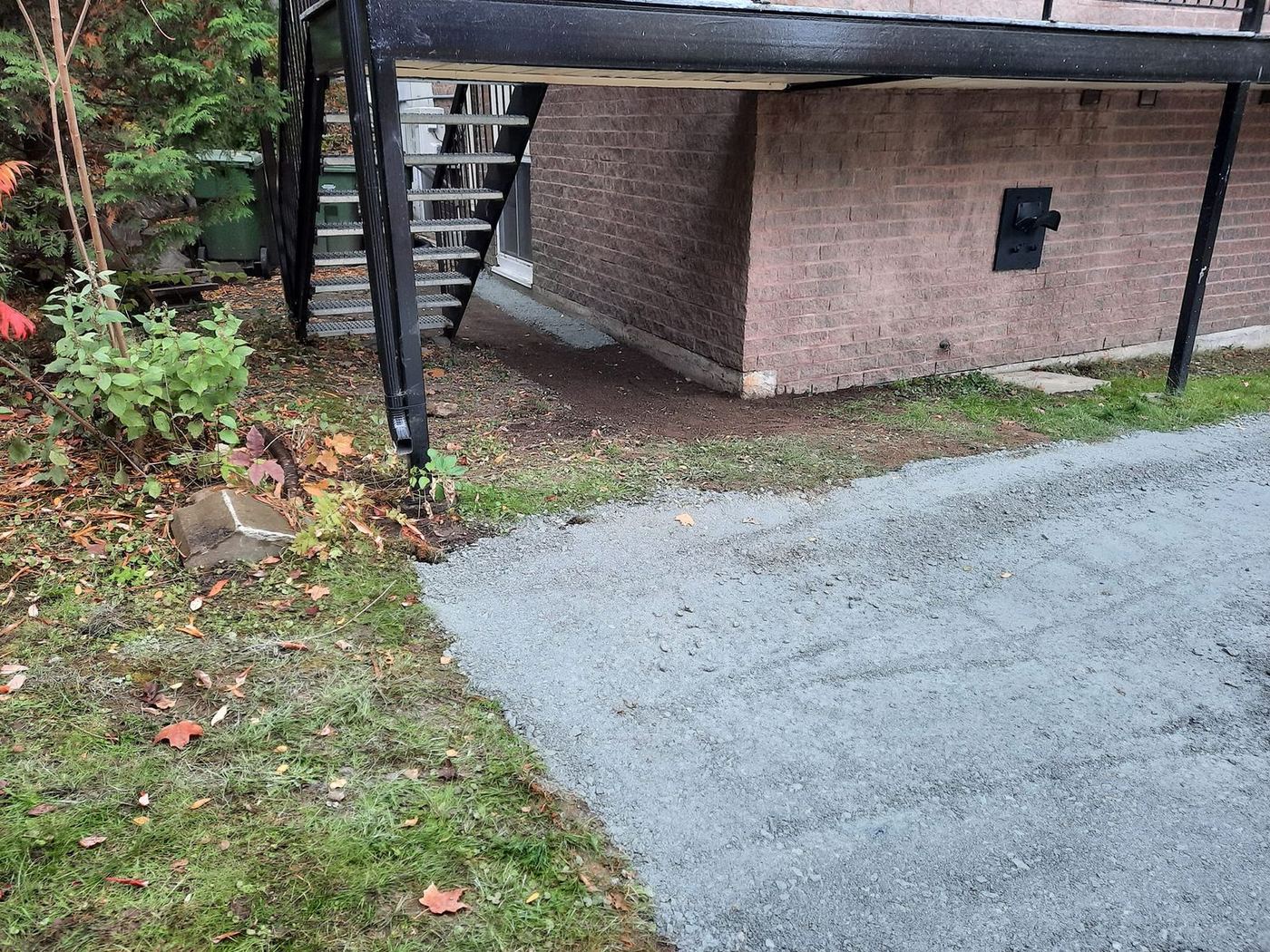 Entrée pavée asphalte grise côté bâtiment brique résidentiel