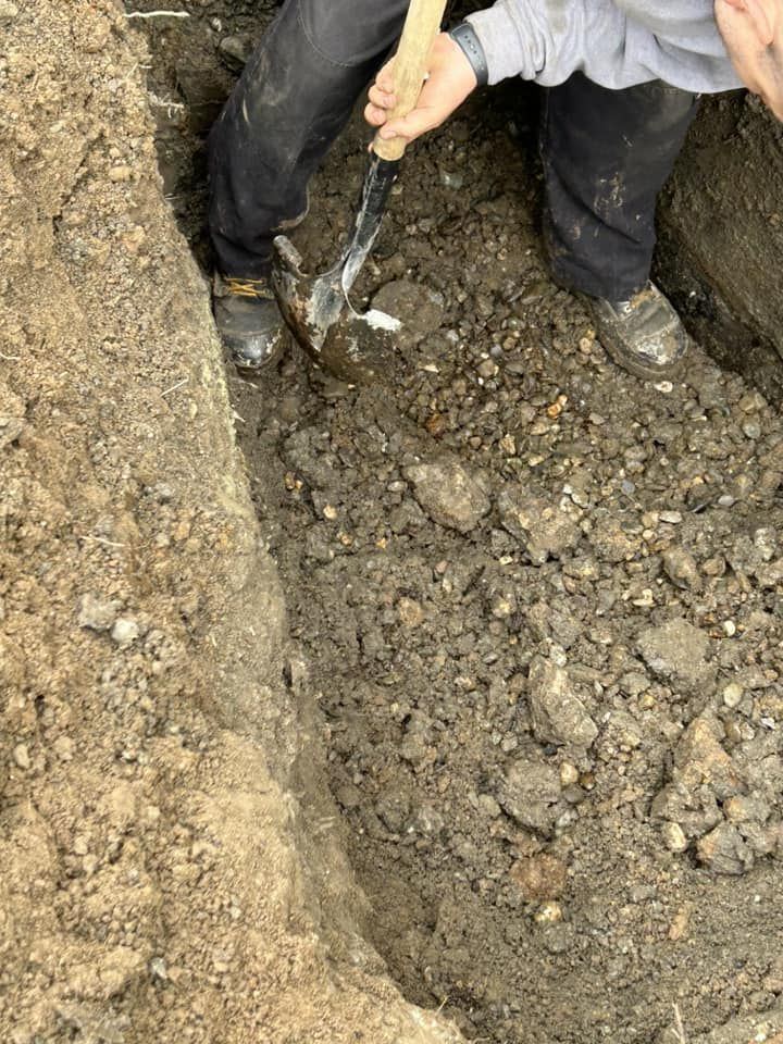 Travailleur dans tranchée drainage pioche sol résidentiel