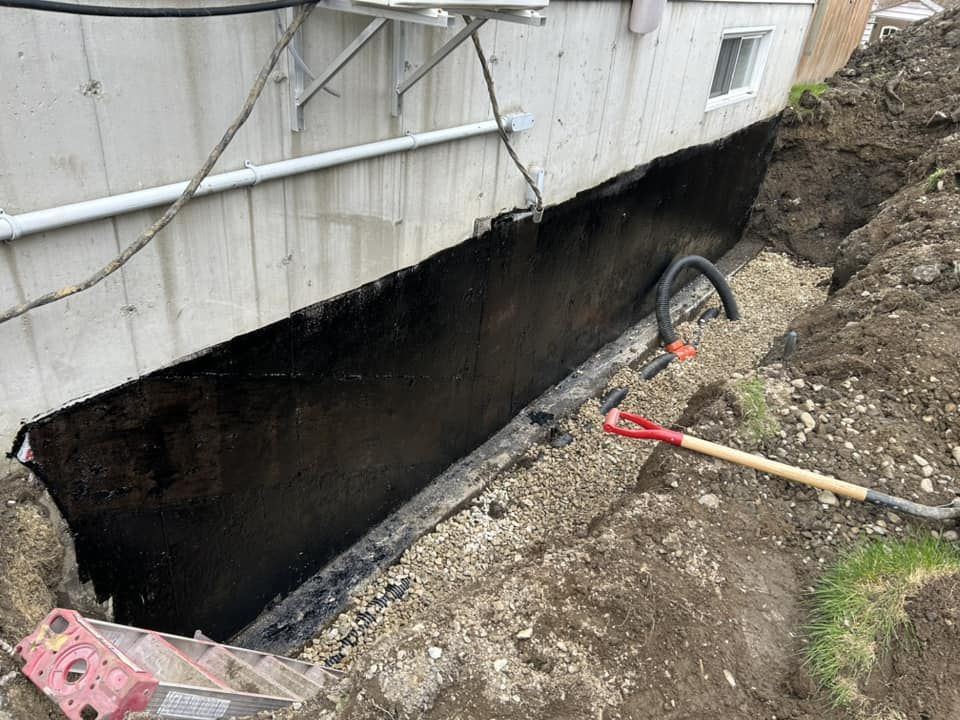 Tranchée drainage fondation membrane noire tuyau flexible installé