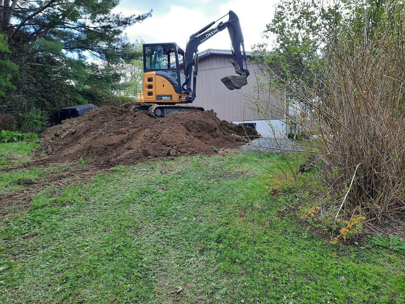 Mini-excavatrice sur butte sol argile maison résidentielle