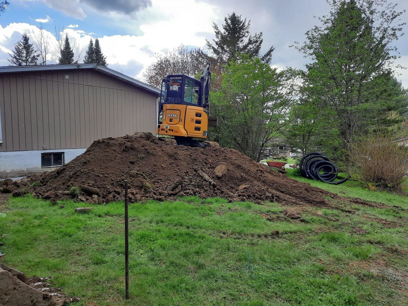 Mini-excavatrice sur butte fosse septique tuyau drainage résidentiel