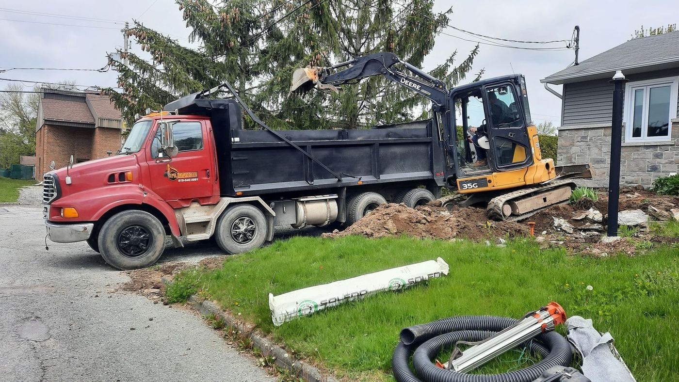 Mini-excavatrice et camion-benne, tranchée drainage résidentiel