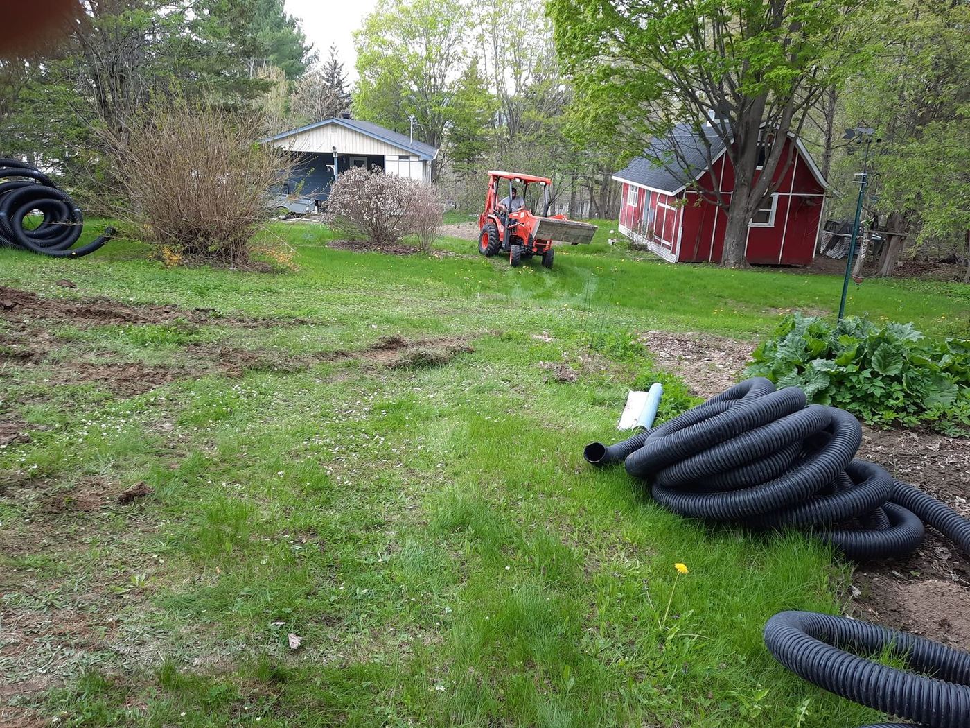 Tuyaux drain et mini-tracteur, cour résidentielle
