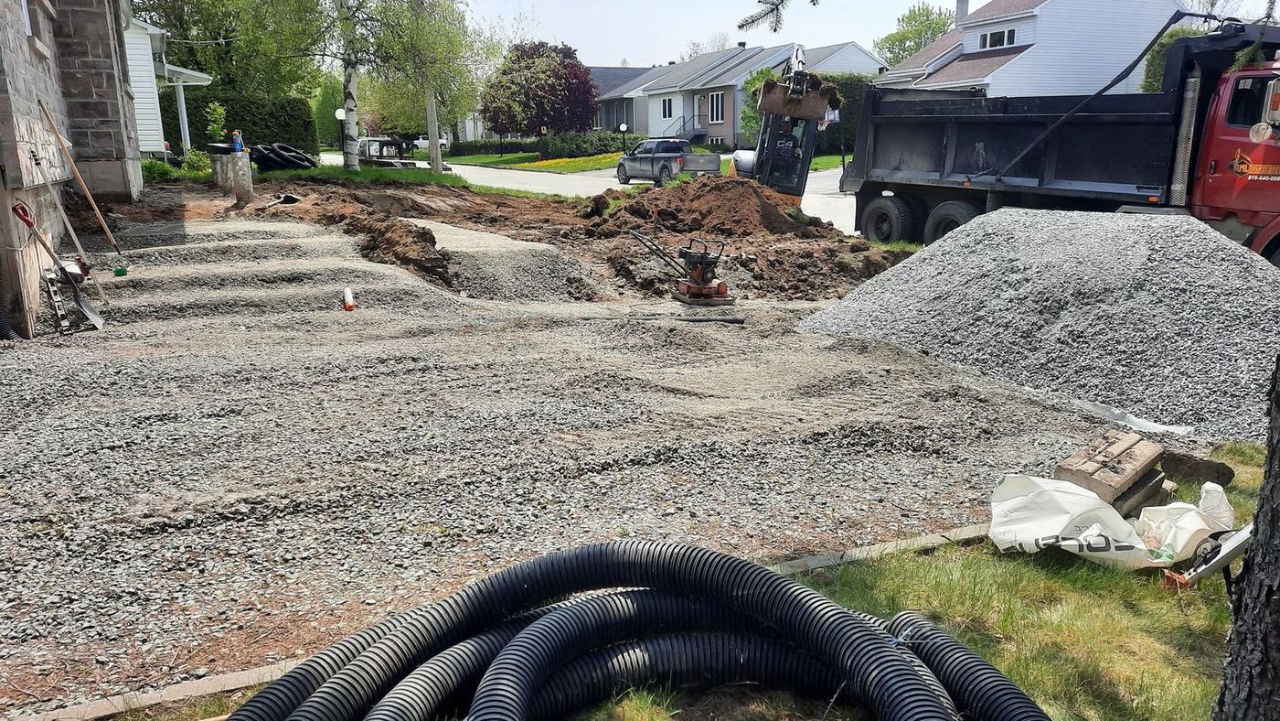 Mini-excavatrice et camion-benne, tranchée latérale maison résidentielle