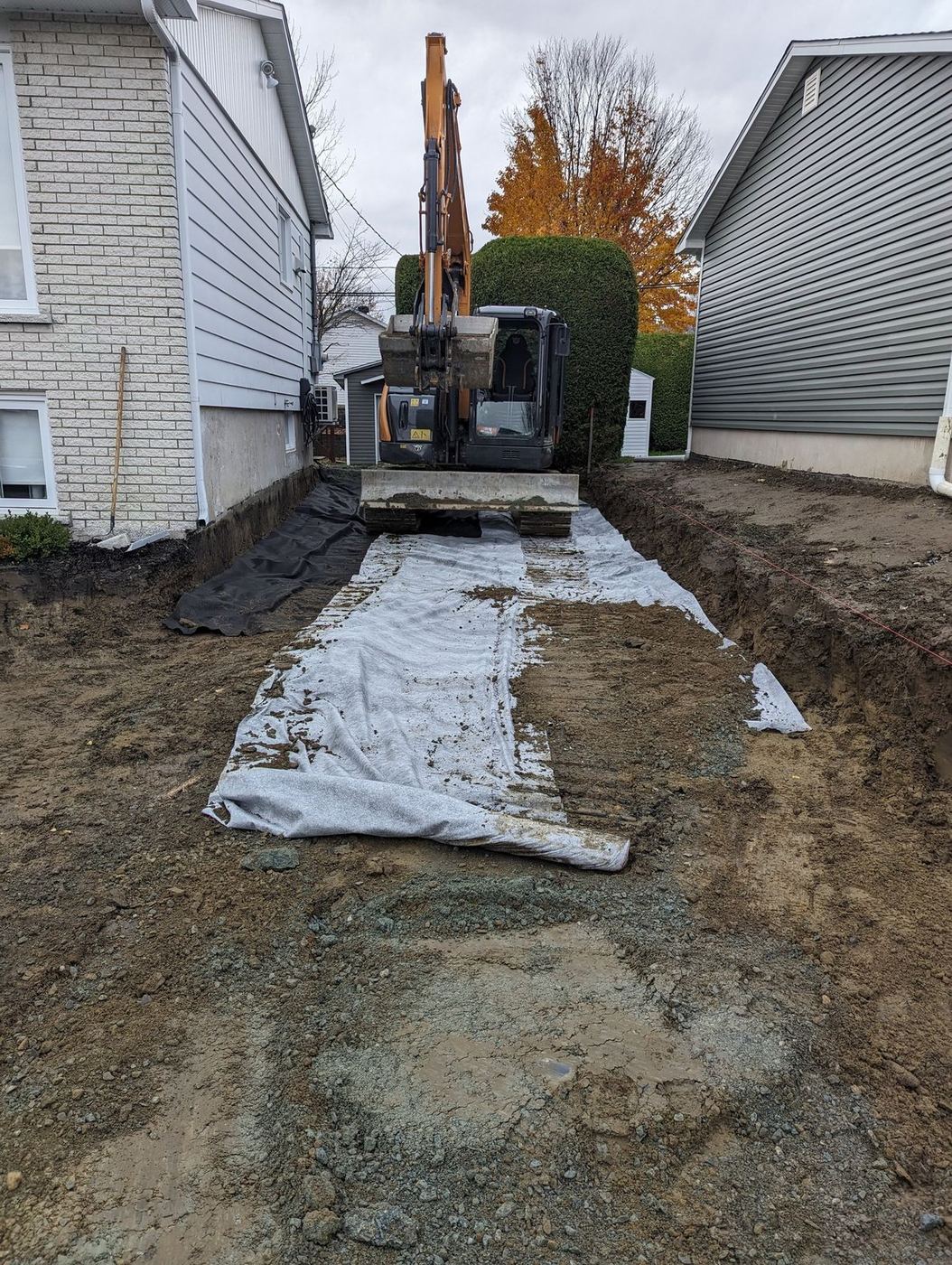 Mini-excavatrice et membrane géotextile, tranchée drain résidentiel