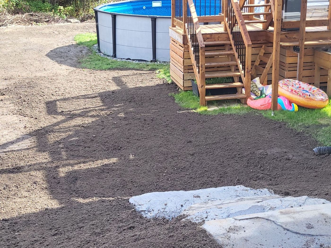 Sol nivelé en terre noire près d'une piscine hors-sol