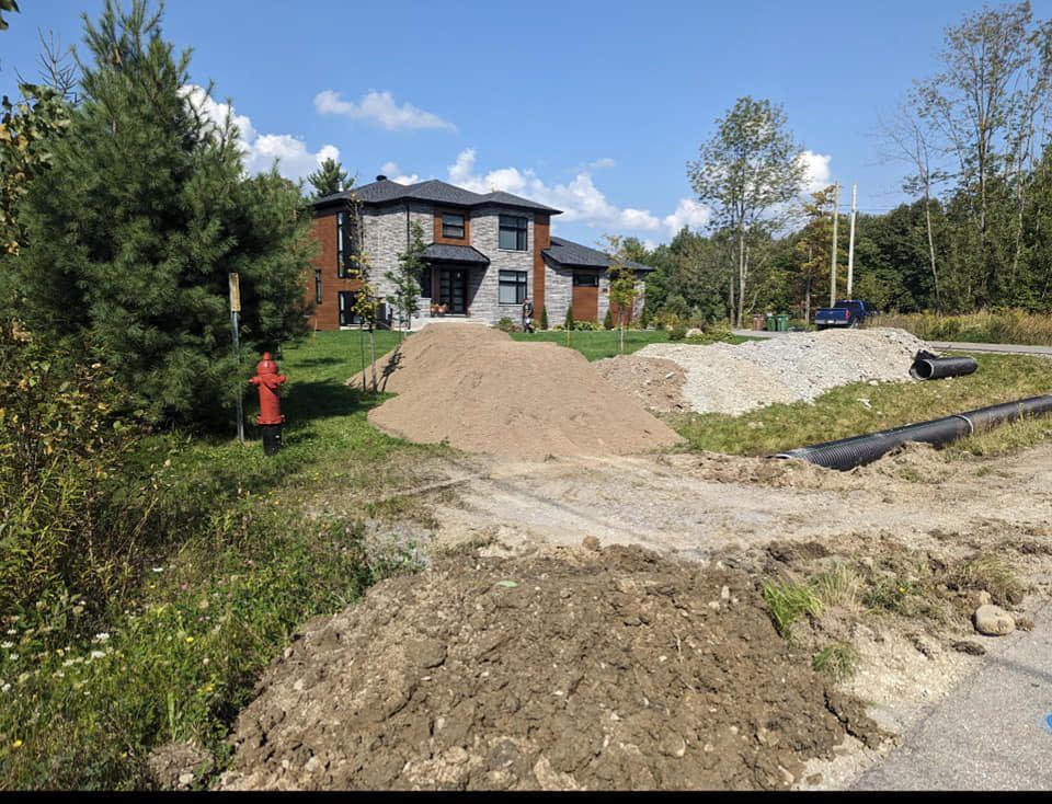 Drainage et matériaux en vrac devant maison moderne neuve