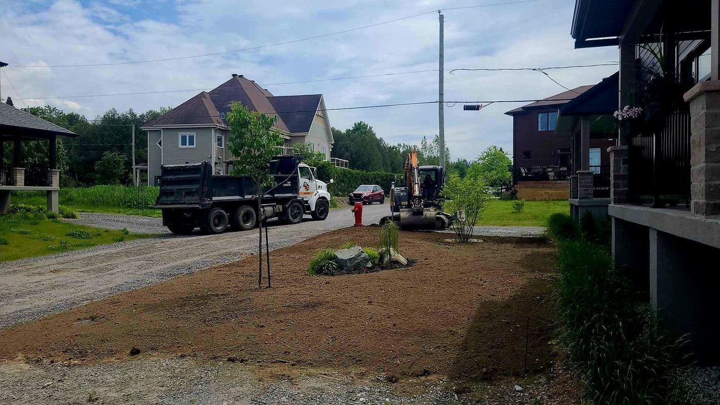 Camion-benne et mini-excavatrice nivelage terrain résidentiel