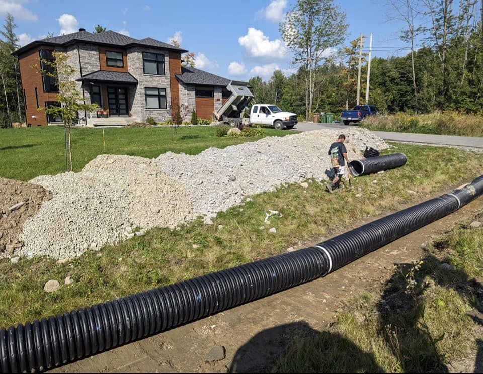 Drain français et tas gravier devant maison pierre moderne