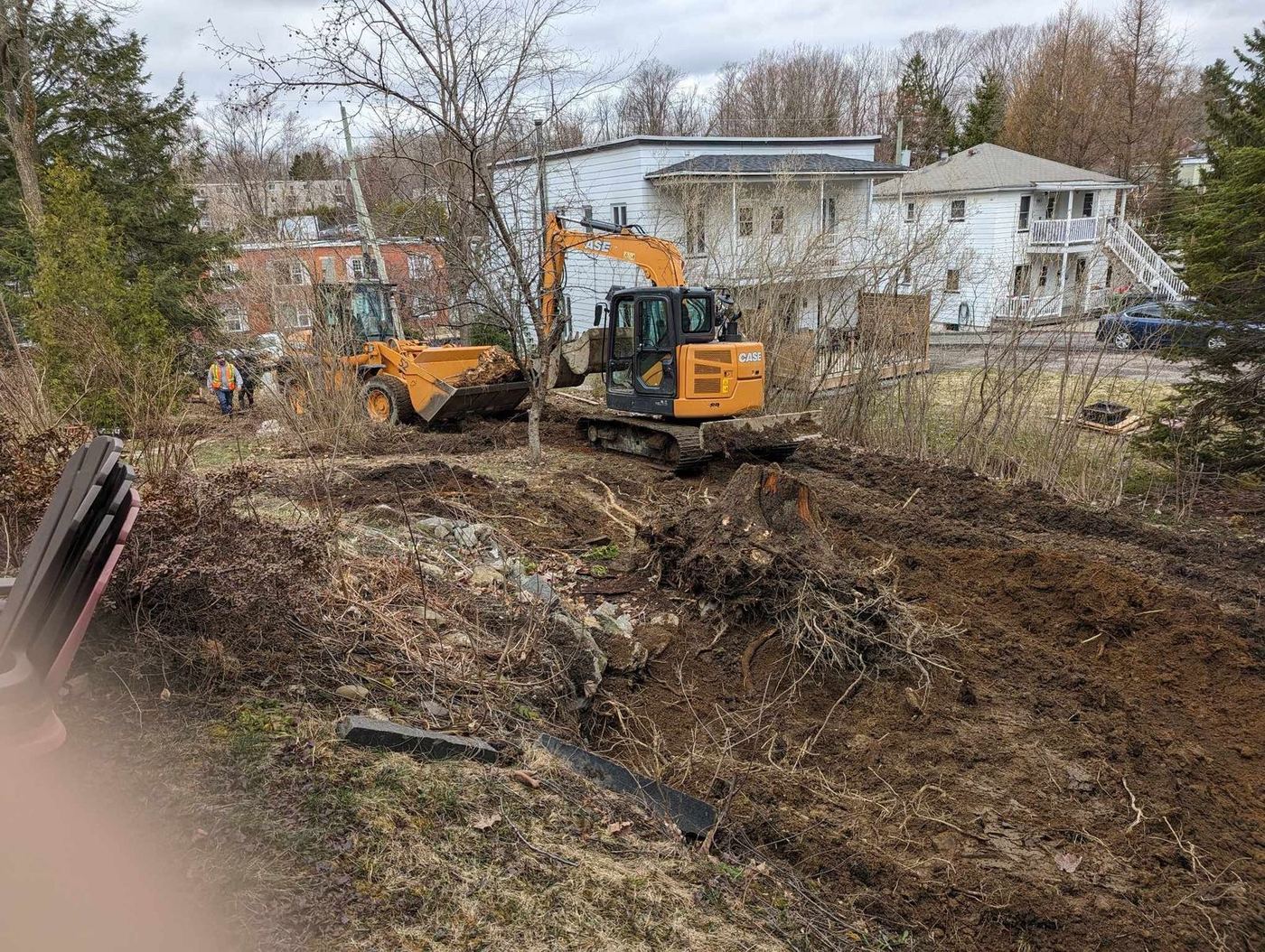 Excavatrice et chargeuse déboisent terrain urbain résidentiel