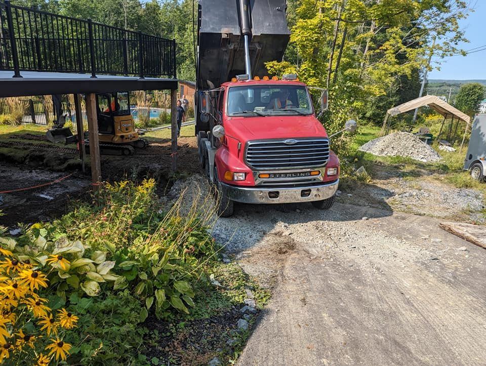 Camion-benne rouge livre matériaux chantier résidentiel boisé