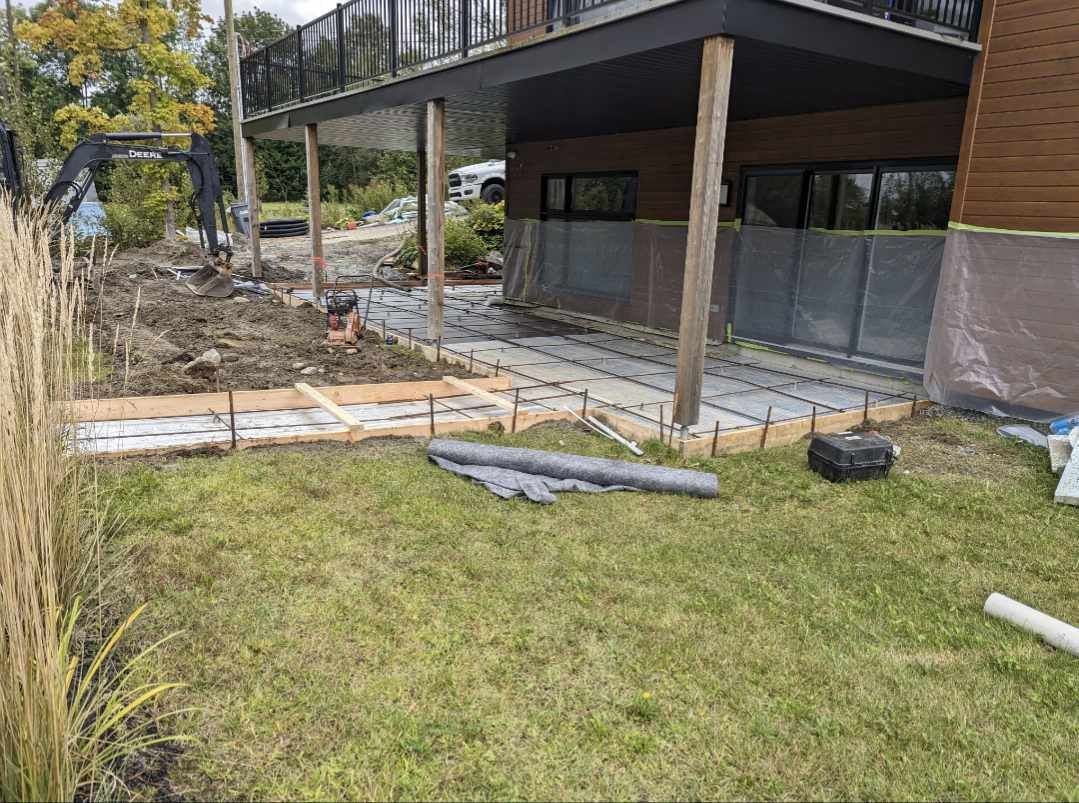 Préparation dalle béton mini-excavatrice sous terrasse résidentielle