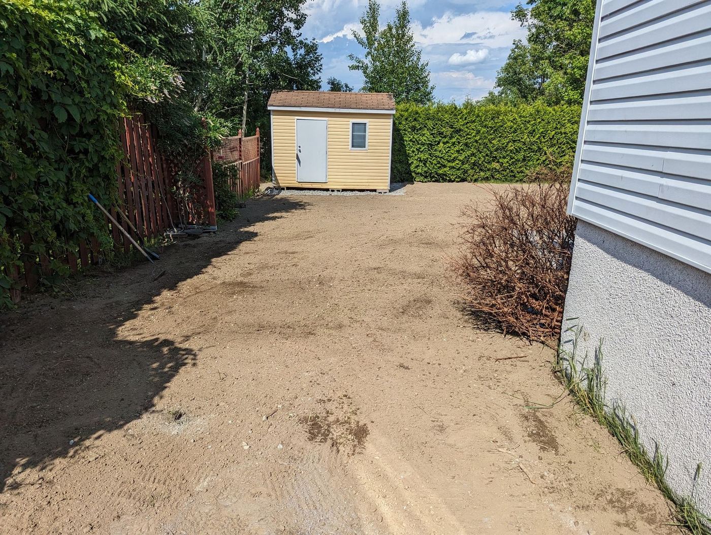 Cour arrière nivelée en sable avant aménagement résidentiel
