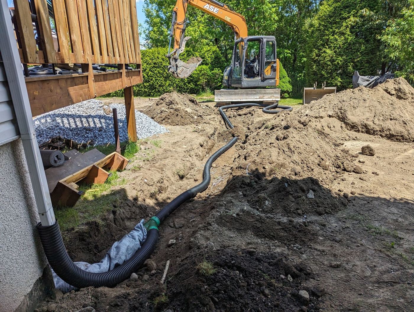 Tranchée drainage tuyaux noirs mini-excavatrice cour résidentielle
