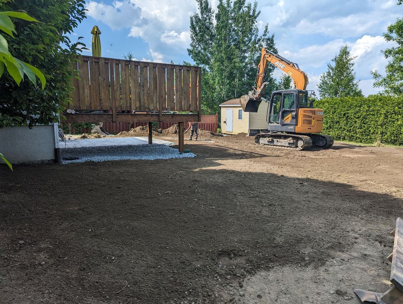 Excavatrice CASE nivele cour résidentielle après démolition piscine