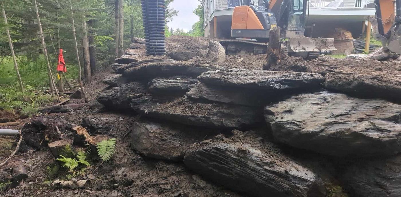 Excavatrice roches calcaires déboisement fosse septique boisé résidentiel