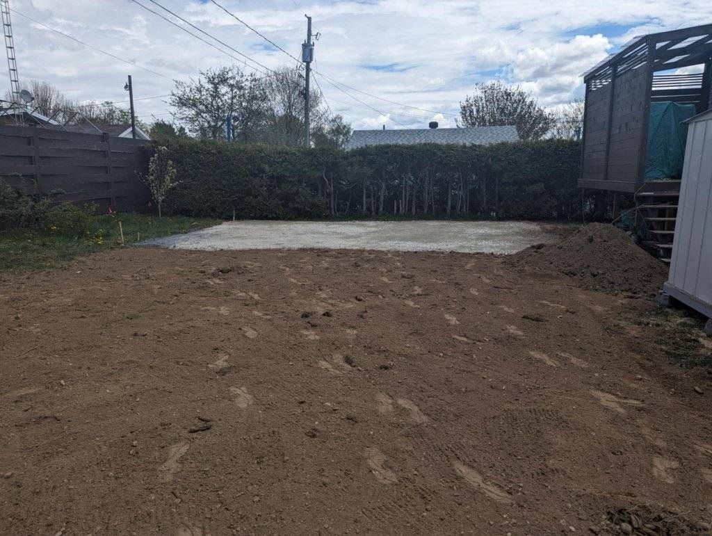Dalle de béton préparée en fond de cour résidentielle, sol nivelé