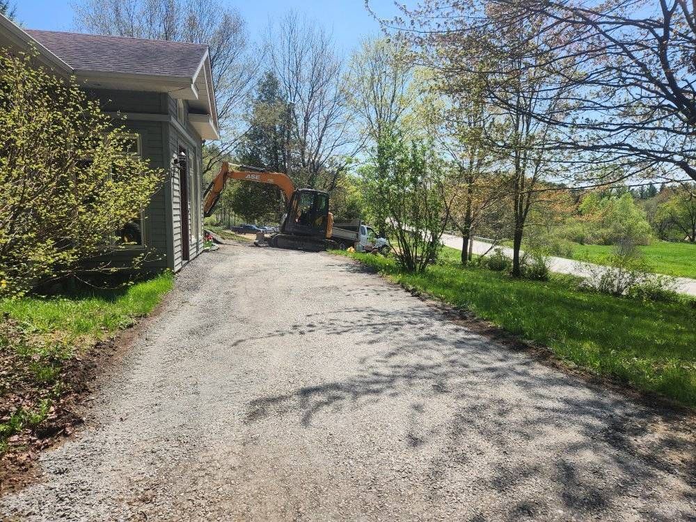 Excavatrice compacte travaille le long de maison, préparation drainage