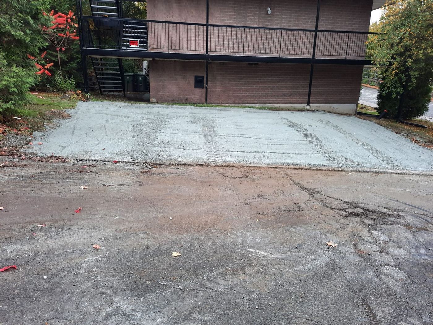 Stationnement asphalte arraché devant bâtiment commercial
