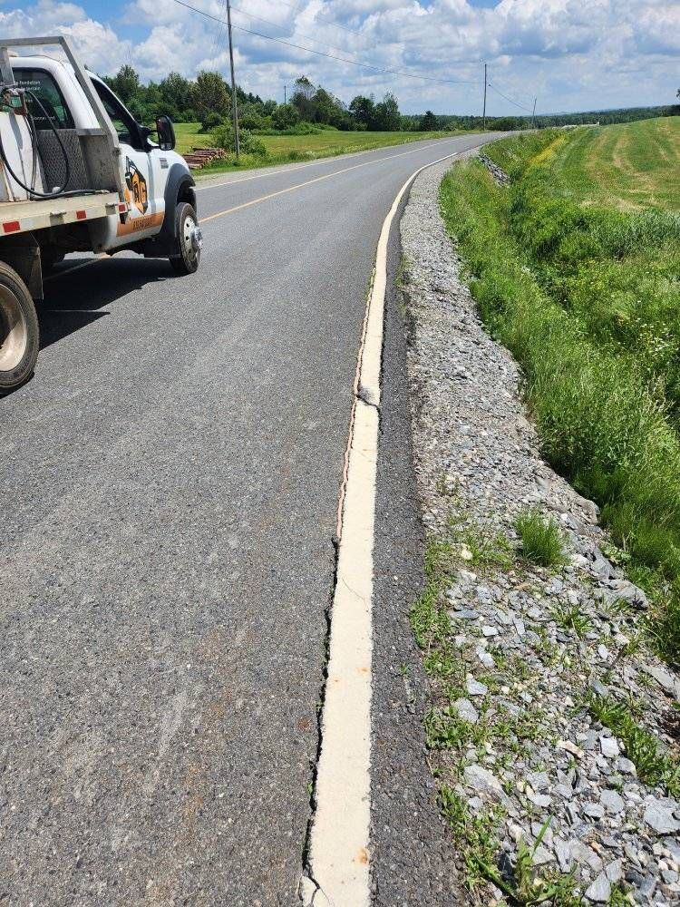 Ligne de scellement blanche fraîche sur bord de route asphaltée