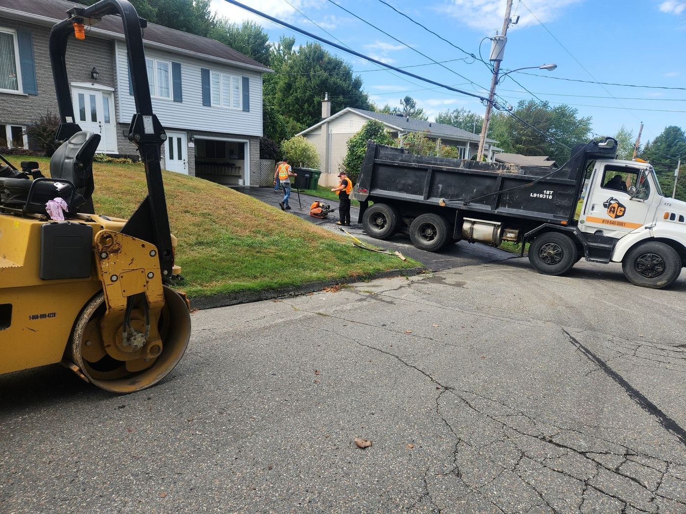 Compacteur et camion-benne, pose asphalte entrée résidentielle en cours