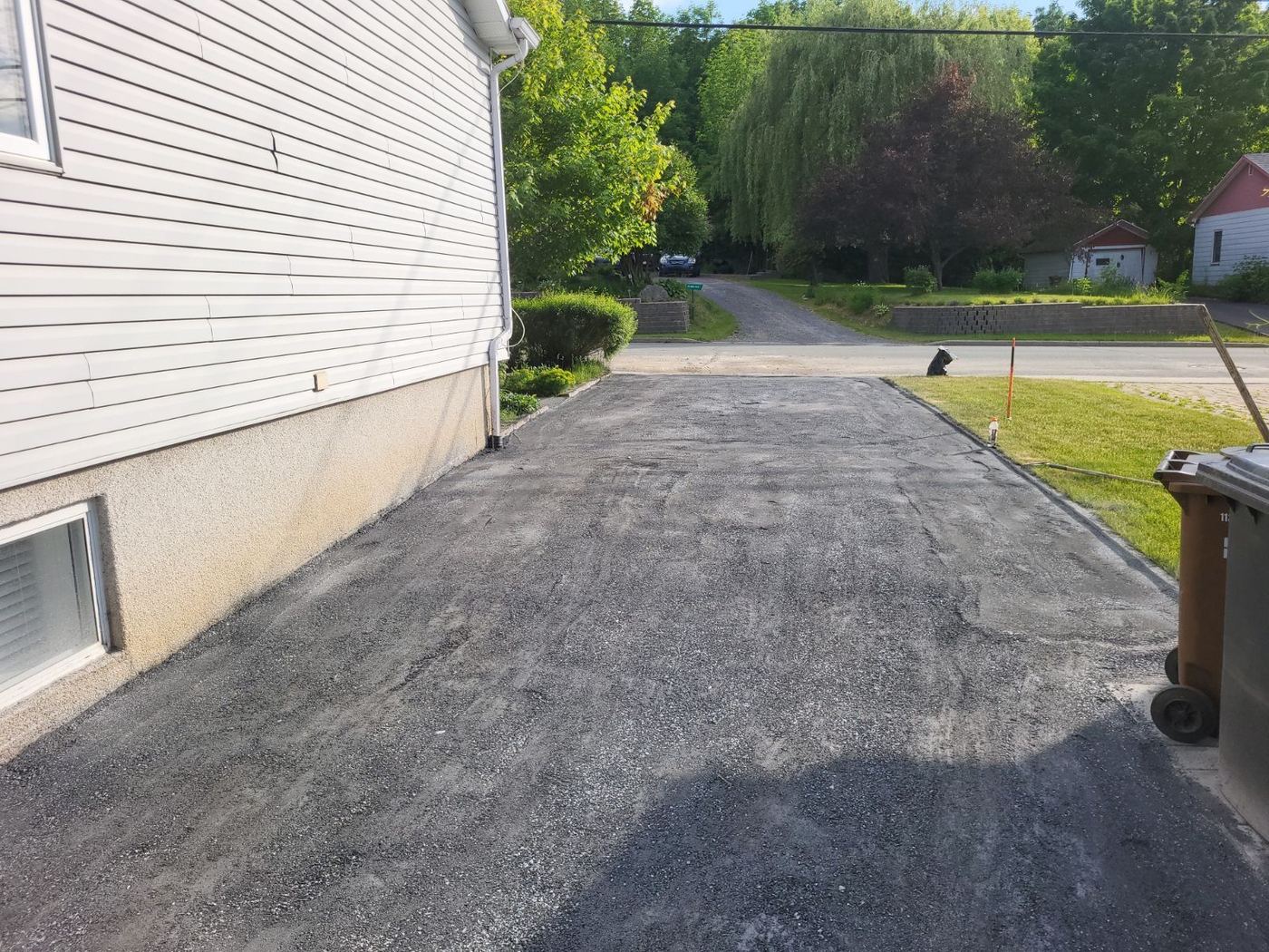 Entrée asphaltée résidentielle avec bordure et clôture