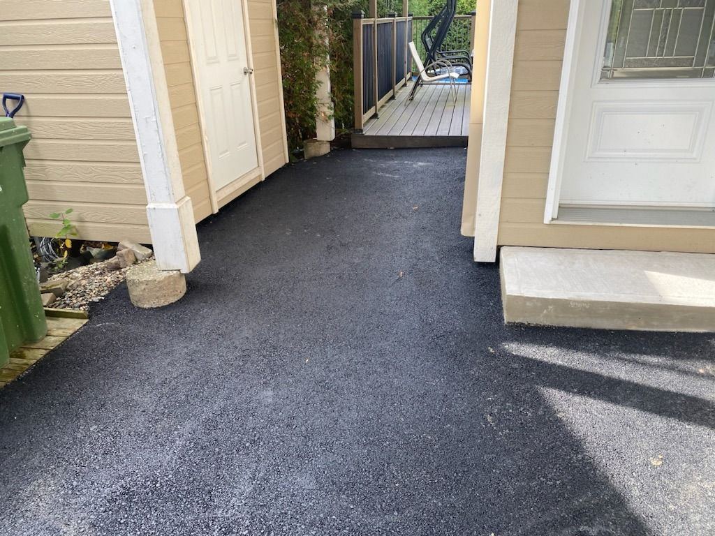 Allée latérale résidentielle asphaltée entre deux bâtiments