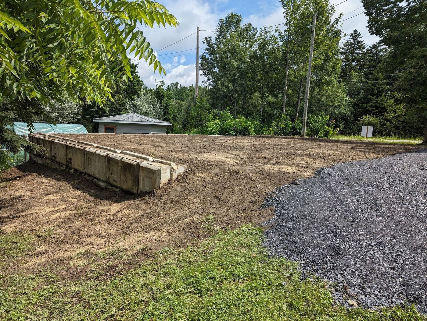 Long muret blocs béton armabloc et terrain nivelé résidentiel