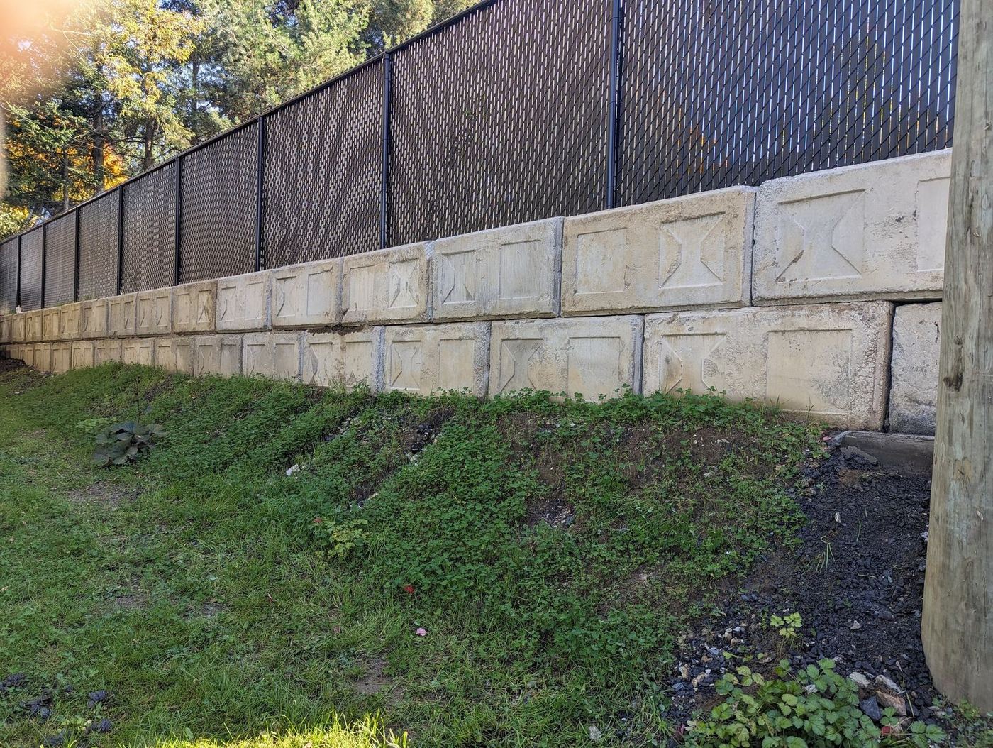 Long muret blocs béton armabloc avec clôture chainlink