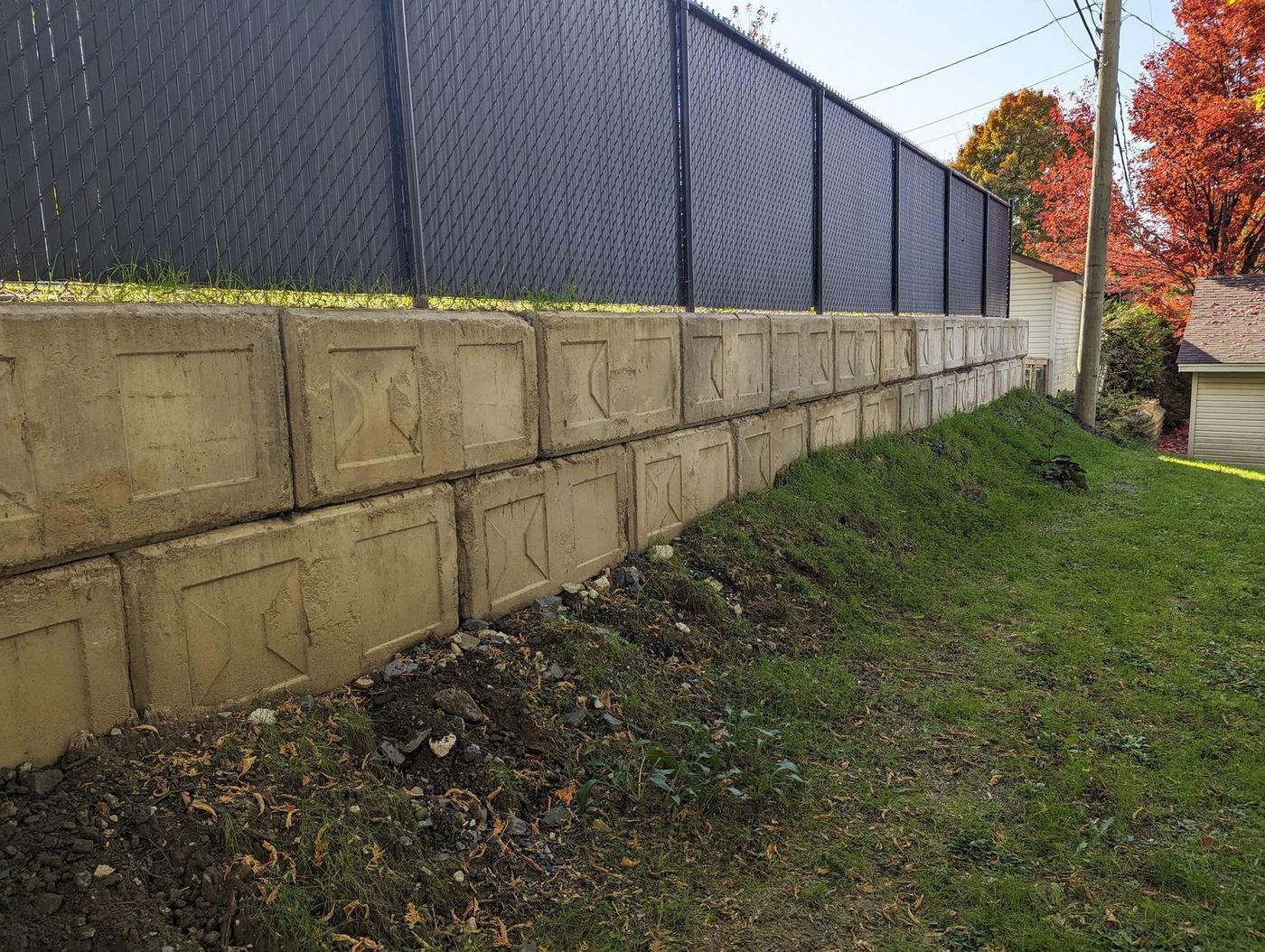 Long muret double rang blocs béton avec clôture noire